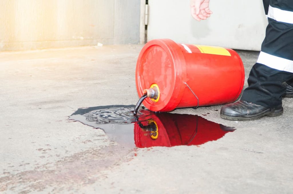 red oil bucket knocked on side spilling oil on floor