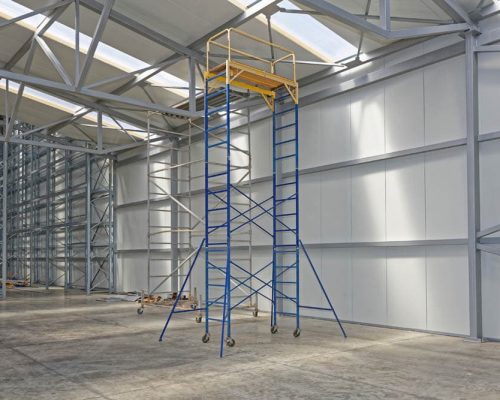 ladders and lifting equipment erected inside unfinished warehouse